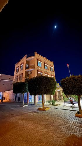 a building with trees in front of it at night at Fibule d'or in Tafraoute