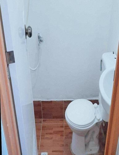 a bathroom with a white toilet and a sink at Balay Baybay Roxas in Roxas City