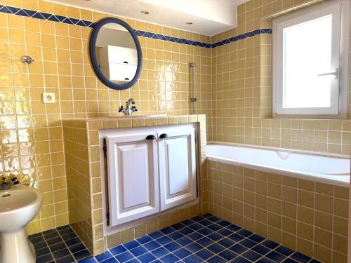 a bathroom with a sink and a tub and a mirror at Villa Pio in Roquebrune-sur-Argens