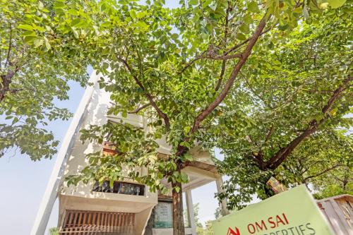 an apartment building with a sign in front of a tree at Super Hotel O Park Inn Near Parashuram Chowk in Morādābād