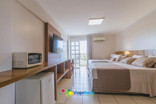 a hotel room with a bed and a tv at DiRoma Exclusive Caldas Novas in Caldas Novas