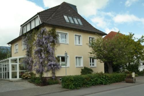 een geel huis met een zwart dak bij Pension Franzbäcker in Warburg