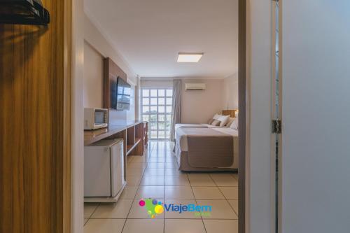 a small room with a bed and a kitchen and a room at DiRoma Exclusive Caldas Novas in Caldas Novas
