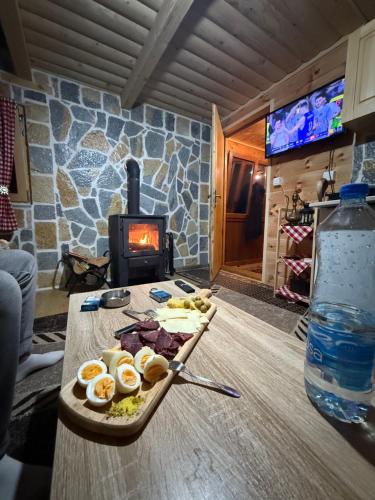 a plate of food on a table with a fireplace at WildBeauty Grebaje in Vusanje
