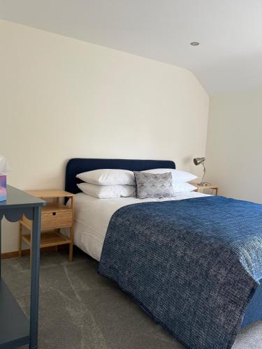 a bedroom with a bed with a blue blanket on it at The Sidings, Wool in Wareham