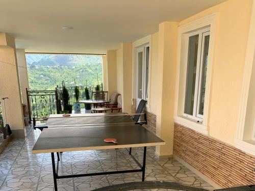 a ping pong table in a room with a balcony at tamazis guest house in Batumi