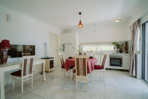 a kitchen with a table and chairs and a kitchen with white appliances at Mahakala Center in Petrovac na Moru