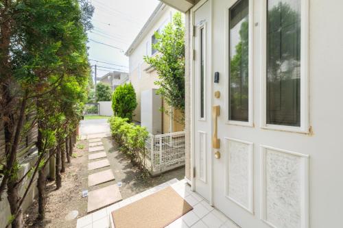 an entrance to a house with a white door at Kamakura Hase House in Kamakura