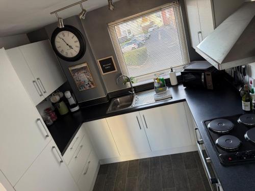 an overhead view of a kitchen with a clock on the wall at Stylish Marina Apartment with Stunning Views in Portishead