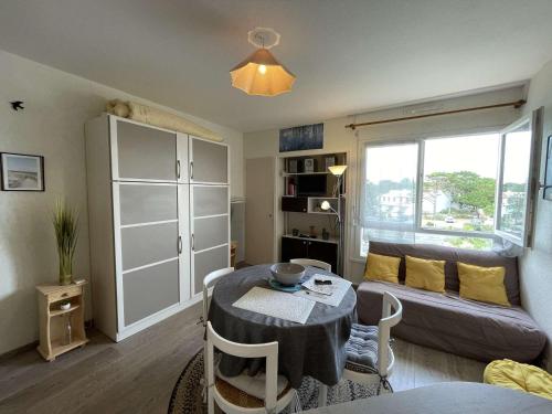 un salon avec une table et un canapé dans l'établissement Studio cosy pour 3 pers. à 100m de la plage avec lave-linge à Saint-Jean-de-Monts - FR-1-224C-51, à Saint-Jean-de-Monts