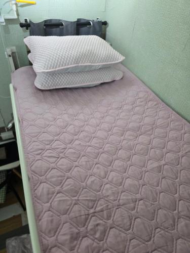 a bed with two pillows on top of it at 113 Olan Place Cozy Loft Apartment with free Wi-fi in Bangkok