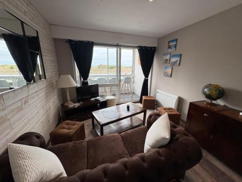 un salon avec un canapé et une table dans l'établissement appartement vue sur port de plaisance, à Courseulles-sur-Mer