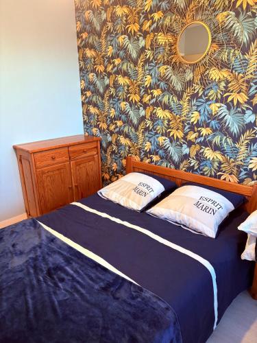 une chambre avec un lit avec deux oreillers dessus dans l'établissement appartement vue sur port de plaisance, à Courseulles-sur-Mer