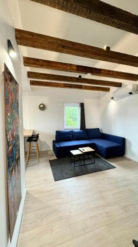 a living room with a blue couch and a table at Charmant appartement 3 pièces proche hyper centre Strasbourg in Strasbourg