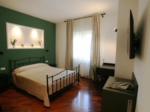 a bedroom with a bed and a desk and a window at Quintadecima Rooms in Palermo