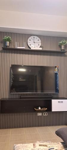 a wall with a clock and a tv in a room at House of Lilith at Kasara in Manila