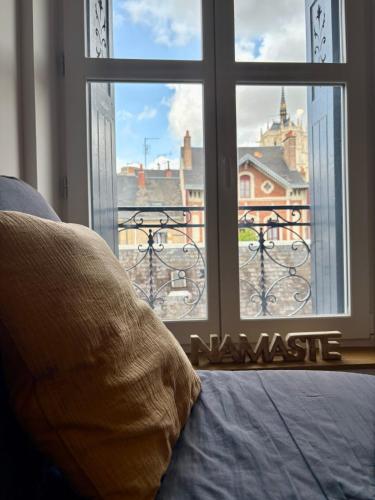a bedroom with a window with a view of a city at Séjour de charme au marais bleu in Amboise