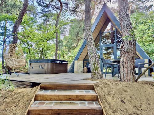 une cabane dans les bois avec un arbre dans l'établissement Chalet CanopéA 28 m2 au Domaine CollinéA, à Bathernay