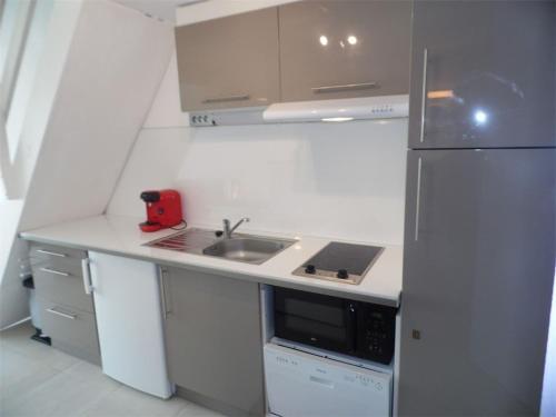 une petite cuisine avec un évier et un réfrigérateur dans l'établissement Studio mezzanine, 4 couchages, 1er étage, parking privé, à 700 m des commerces, Grau d'Agde - FR-1-423-39, au Grau-dʼAgde