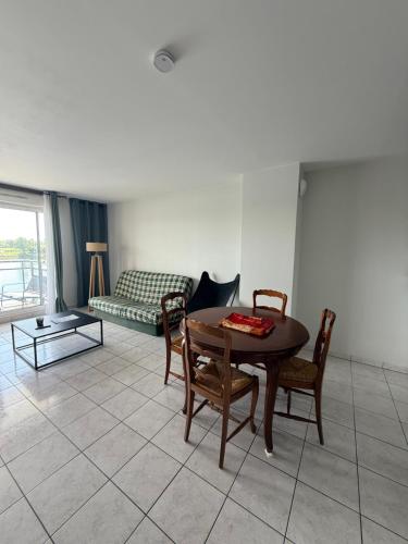 un salon avec une table, des chaises et un canapé dans l'établissement Appartement en bord de seine, à Ablon-sur-Seine