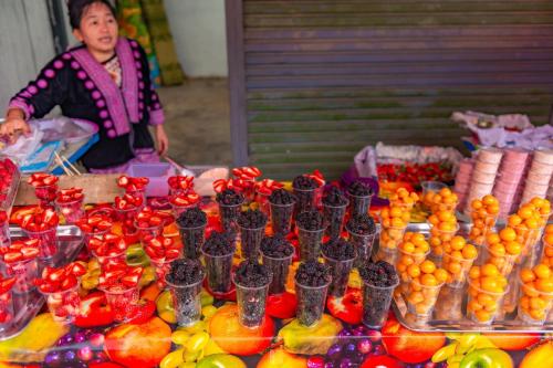a woman standing in front of a display of fruit at กรีนโซน แคมป์ปิ้ง in Ban Chek
