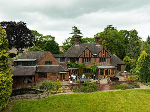 a large brick house with people standing in the yard at Chimneys Hot Tub Country Escape in Stourbridge