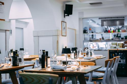 a restaurant with wooden tables and chairs with wine glasses at Second Life in Piran - Hotel Zala Piran with private parking and shuttle service in Piran
