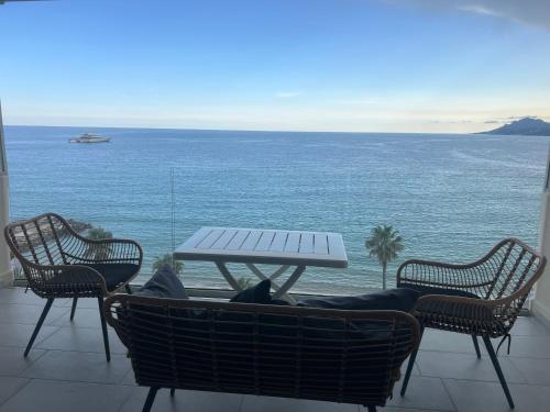 une table et des chaises avec vue sur l'océan dans l'établissement Sea View Bellamare next Palais Festival, à Cannes