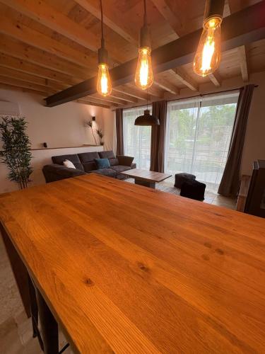 - un salon avec une grande table en bois et un canapé dans l'établissement Appartement Loft, à Mirepoix
