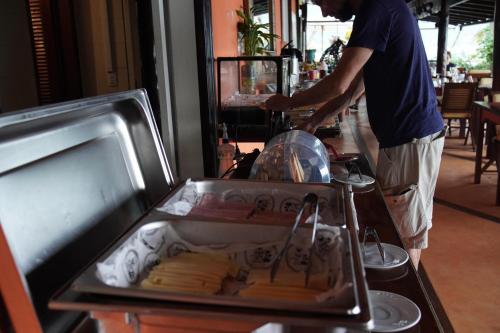 a man preparing food on a counter in a restaurant at Casa da Ilha & SPA in Abraão