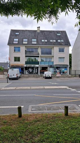 un grand bâtiment avec deux voitures garées devant lui dans l'établissement Superbe loft 90m² proche parc expo Nantes (6p), à Nantes