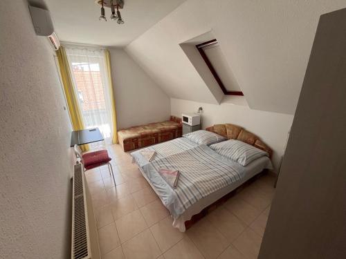 a bedroom with a bed and a chair in it at Klassz Apartmanház in Balatonfüred