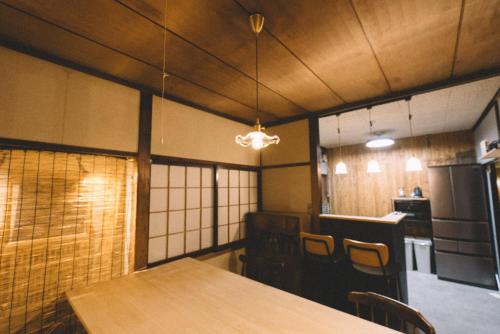 a room with a table and chairs and a kitchen at guesthouse TANDEM in Matsumoto