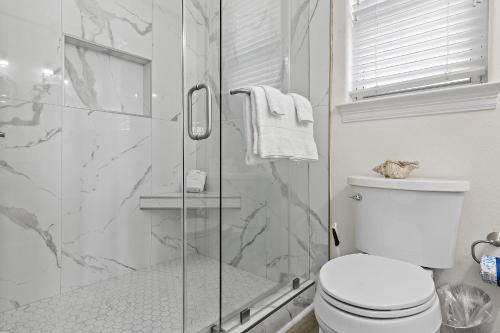Un baño con inodoro y ducha de cristal. en Destiny Beach Villas #15A&B, en Destin