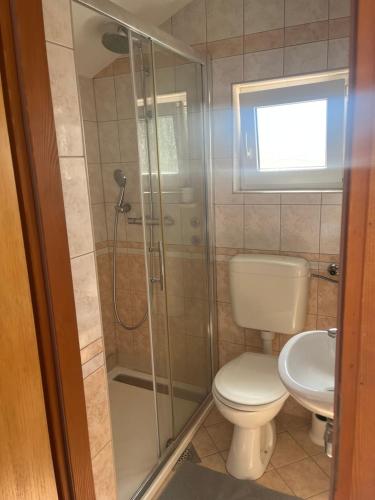 a bathroom with a toilet and a glass shower at Ocean Pearl in Vodice