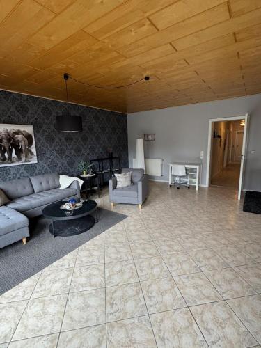 a living room with couches and a wooden ceiling at Idas stuga in Wächtersbach