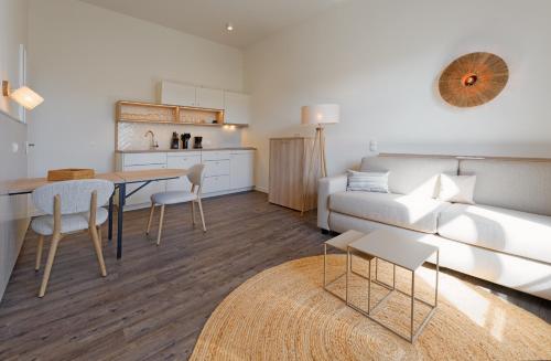 a living room with a couch and a table at Appartementhaus Meeresburg in Norderney