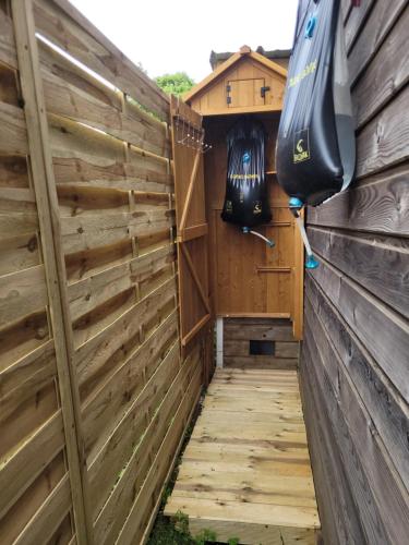 une clôture en bois avec une pirogue contenant un kayak dans l'établissement Au bord de l'eau, à La Neuville-aux-Tourneurs