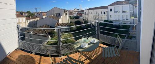 un balcon avec une table et des chaises sur un immeuble dans l'établissement Comtesse, à La Rochelle