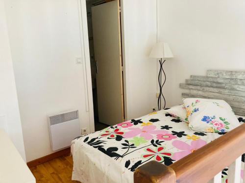 une chambre avec un lit avec une couette fleurie dans l'établissement Comtesse, à La Rochelle