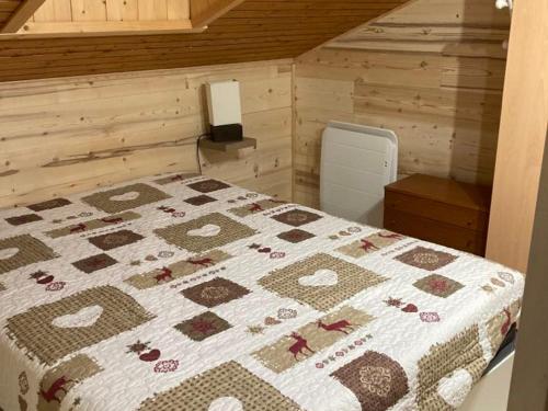 une chambre avec un lit avec une couette dessus dans l'établissement Appartement au pied des pistes avec balcon ensoleillé - 2 ch, 2 sdb, accès rapide au centre village - FR-1-467-85, au Grand-Bornand