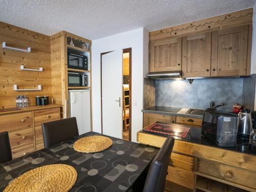 - une cuisine avec une table, des chaises et un comptoir dans l'établissement Studio Cosy pour 4 Pers, Proche Remontées Mécaniques et Centre, Balcon Sud, Parking Inclus - FR-1-676-121, à Châtel