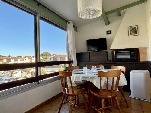 une salle à manger avec une table et une grande fenêtre dans l'établissement Studio à Argelès-sur-Mer avec piscine et animaux admis - FR-1-225-826, à Argelès-sur-Mer