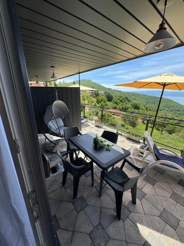 a patio with a table and chairs and an umbrella at Velestovo Panorama House in Velestovo