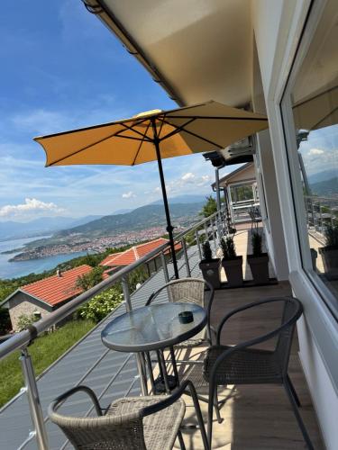 a balcony with a table and chairs and an umbrella at Velestovo Panorama House in Velestovo