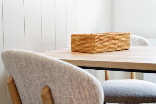 a table with two chairs and a basket on it at Appartementhaus Meeresburg in Norderney