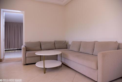 a living room with a couch and a table at VILLA CHEZ IMANE avec piscine chauffée a Orangeraie Dyar Shemsi in Riaïna