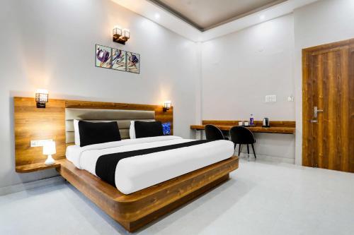 a bedroom with a large bed and a desk at Townhouse Oak Haldwani Kathgharia Chowk in Haldwāni