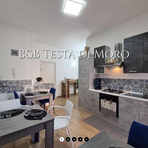 a kitchen and living room with a table and chairs at B&B testa di Moro in Giarre