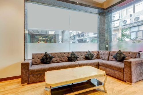 a living room with a brown couch and a table at Townhouse Oak Paharganj Delhi Railway Station in New Delhi